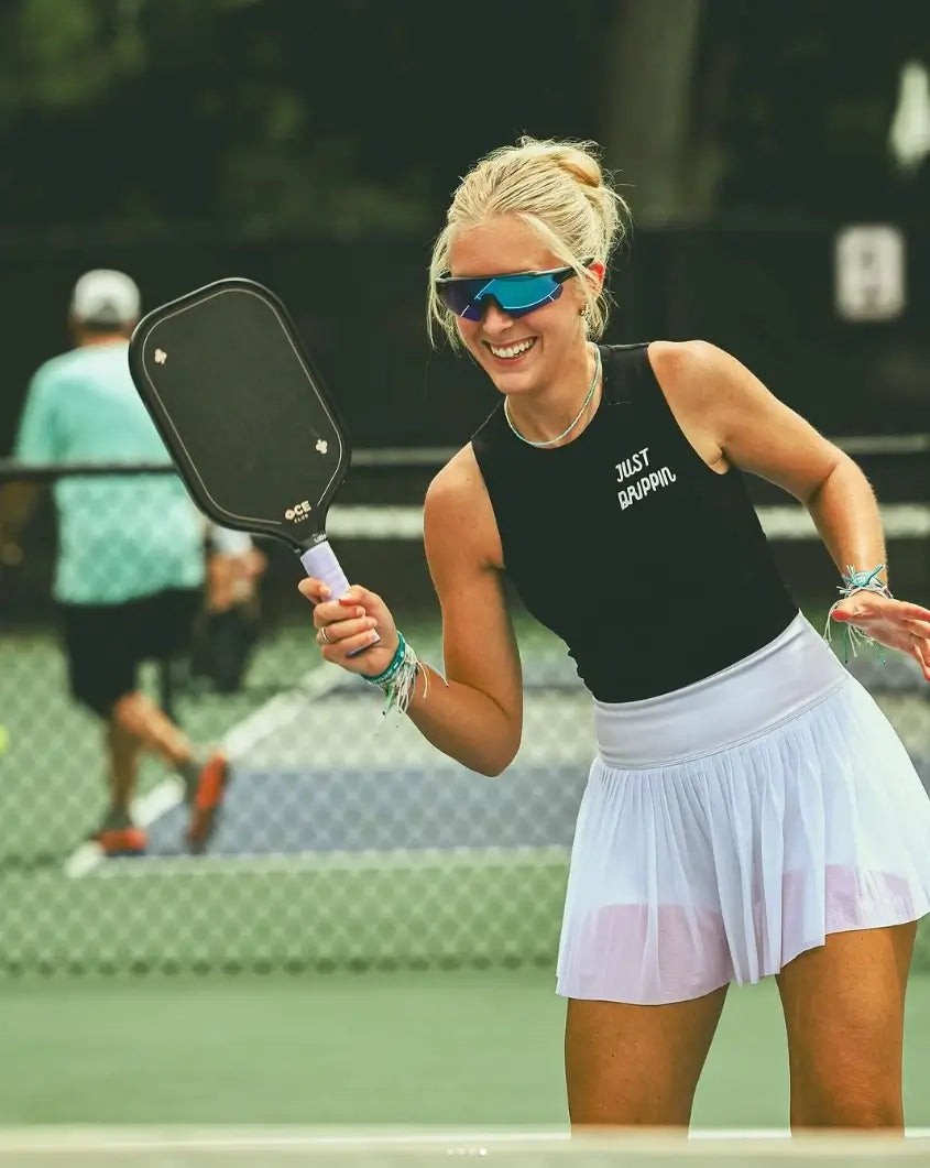 Young lady playing pickle ball using Udrippin overgrips and Udrippin sunglasses